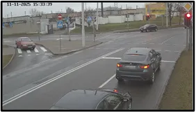 OV camera view of an intersection with an SUV and other vehicles in traffic, a traffic light visible in the distance