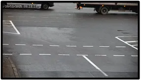 Exit LPR camera view of a truck driving away from the intersection across marked parking and lane lines