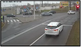 TL camera view of a multi-lane approach with vehicles in the distance and a turn-lane arrow marking on the road