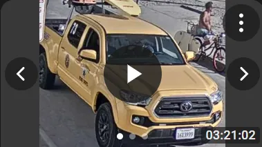 Snapshot of the yellow Toyota truck parked near the beach with a cyclist and pedestrians nearby