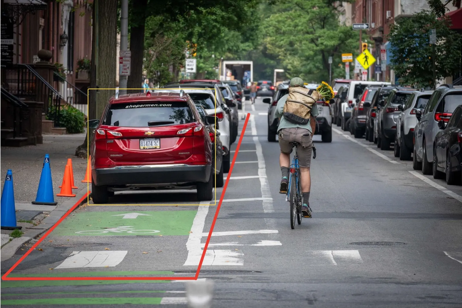 Car parked in a bike lane boxed in yellow with the lane outlined in red, classified as a Not a bike event