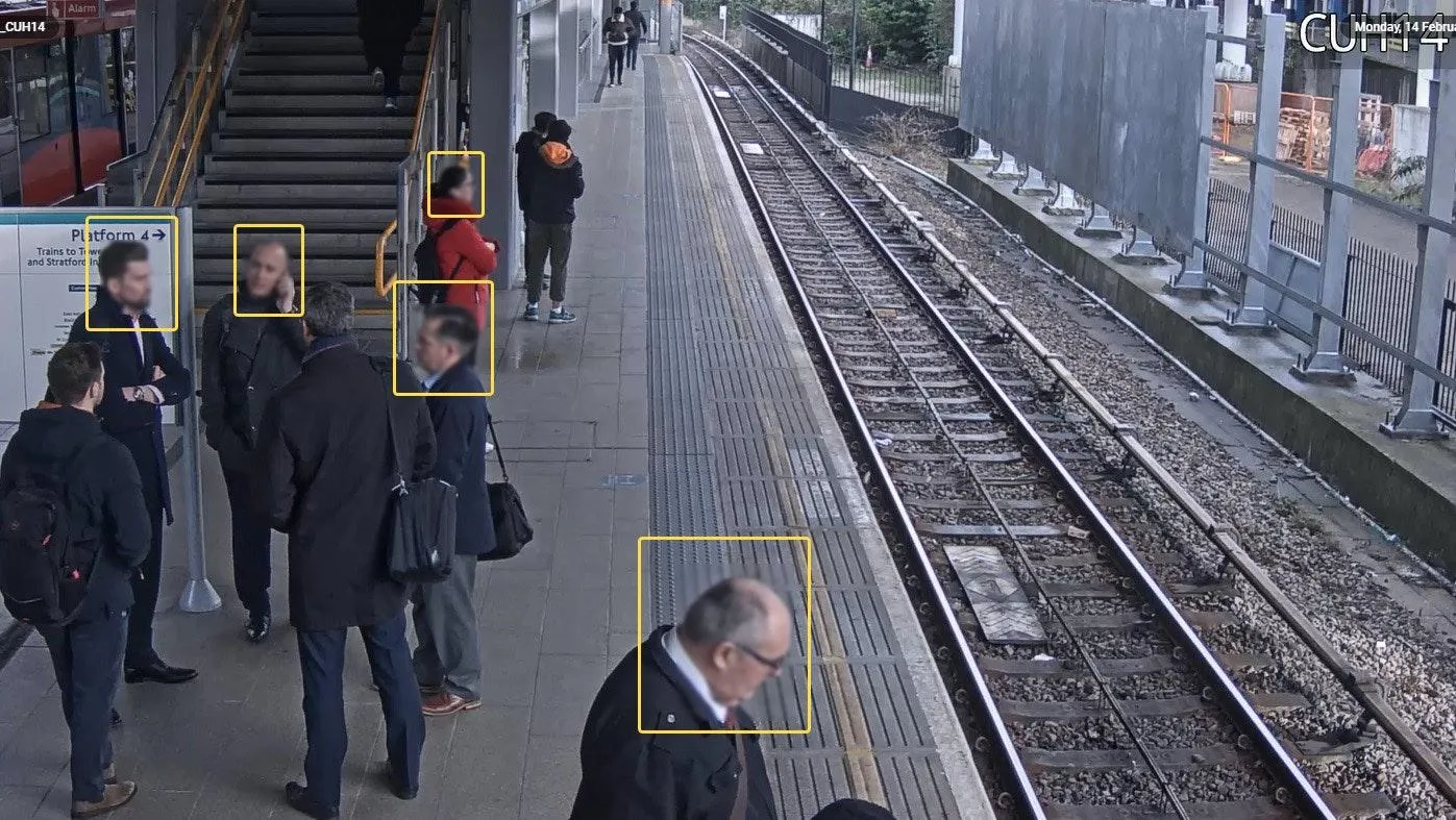 Train platform camera view with FaceTrack Pro yellow bounding boxes around several detected faces